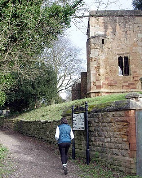 Person walking up track with ruins of Annesley Old Church above