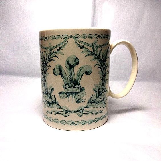 Commemorative mug designed by Carl Toms - green design with royal insignia on cream mug