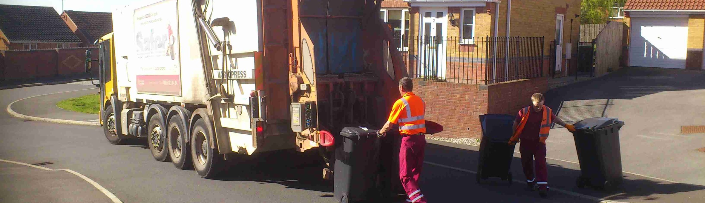 Bin men loading bins onto the bin lorry