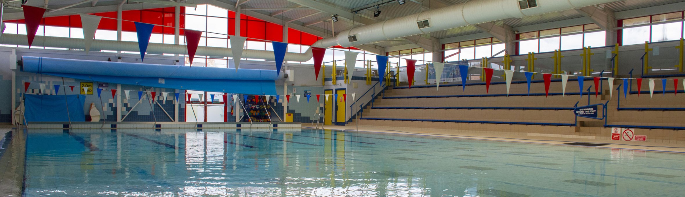 A view of an empty swimming pool with bunting across the roof