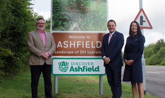 Martin Rigley, Cllr Jason Zadrozny, and Theresa Hodgkinson, CEO stand in front of Ashfield road sign