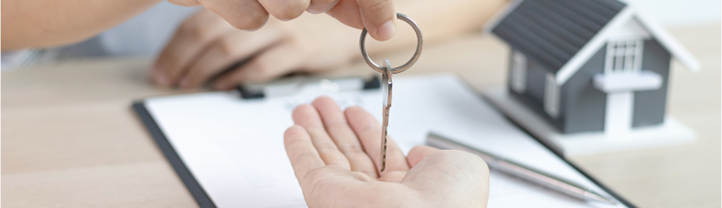 a person handing over a set of keys for a rented property 