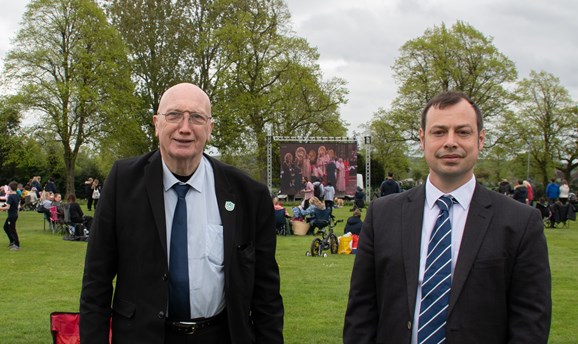 Cllr John Wilmott and Cllr Lee Waters standing in front of a large cinema screen in suits