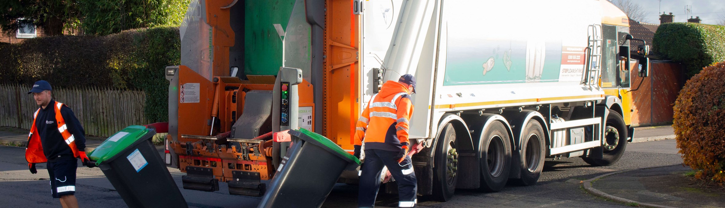 Waste team on their round, emptying bins into a bin lorry