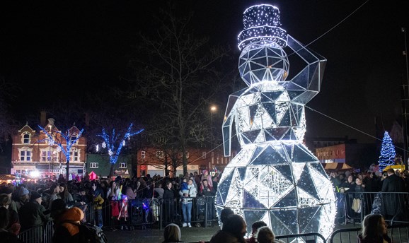 Crowds stand around a giant LED snowman in Hucknall 