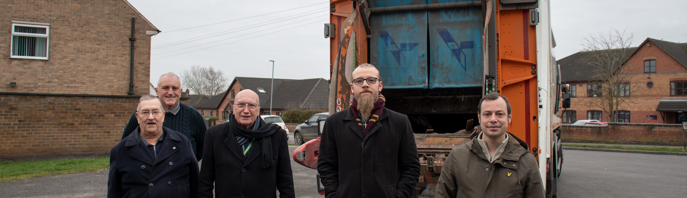 five male councillors stand in front of a bin lorry in hucknall