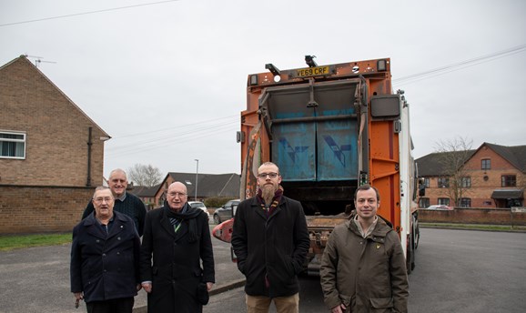five male councillors stand in front of a bin lorry in hucknall