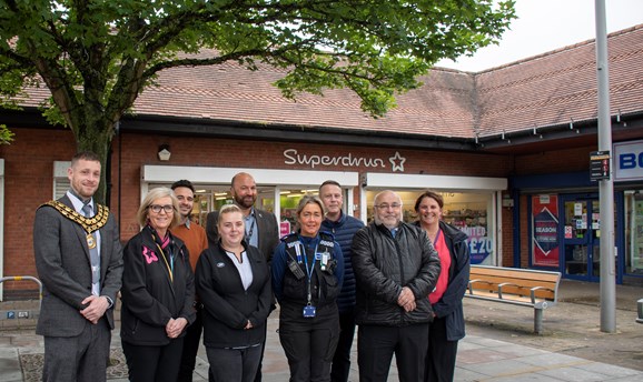 Councillors, officers and shop staff stand outside Superdrug in Kirkby, smiling at the camera 