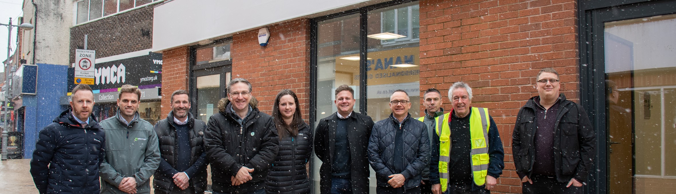 A group of people wearing High-vis vests smiling at the camera 