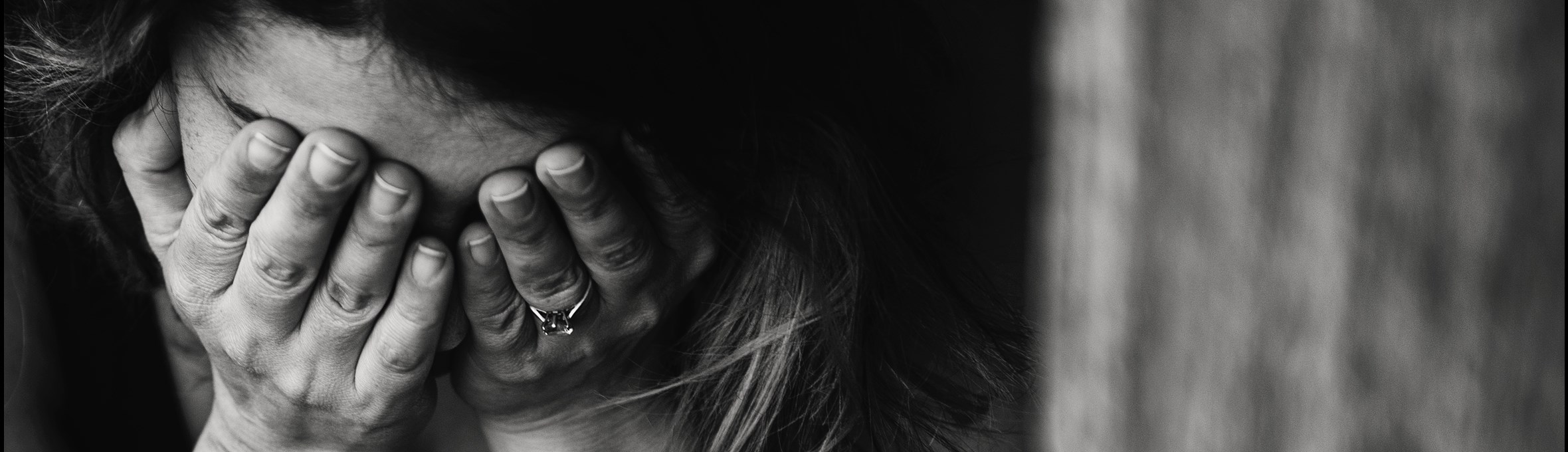 A woman with her head in her hands in black and white