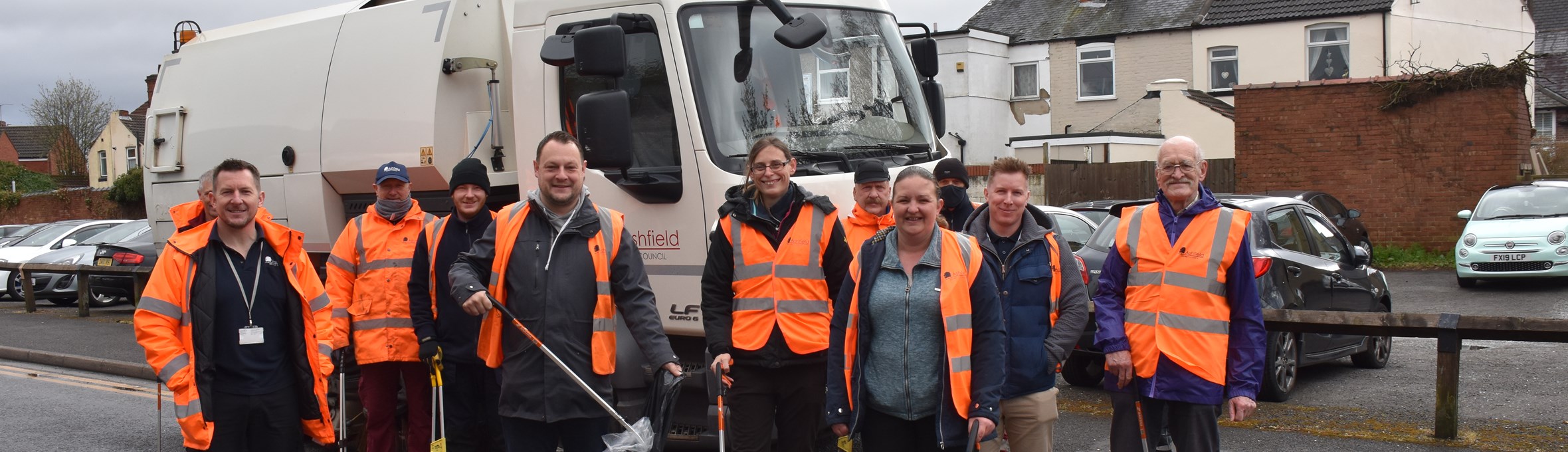 Refuge vehicle on street with councilors, volunteers and picking equipment 